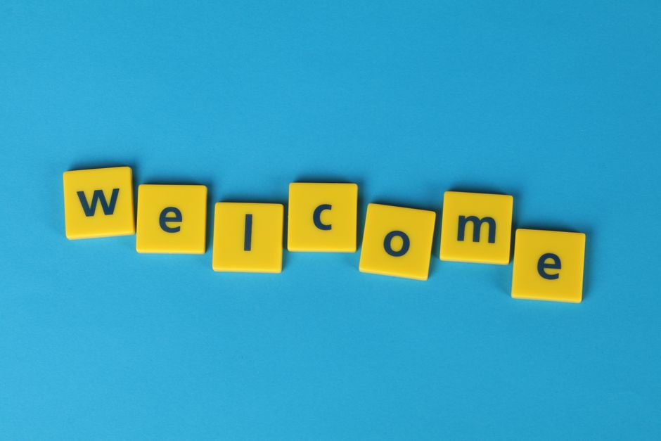 Yellow tiles spelling 'welcome' on a blue background, perfect for greetings.